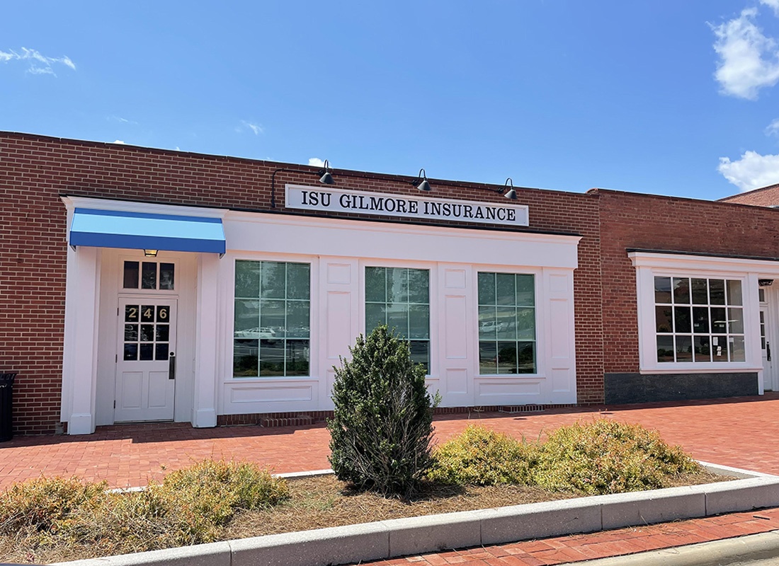 About Our Agency - Exterior View of the ISU GIlmore Insurance Brick Building Against a Clear Blue Sky with a Paved Walkway in the Front