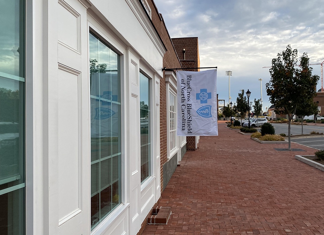 Contact - Side View of the ISU Gilmore Insurance Office Building with a Blue Cross Blue Shield Flag Hanging on the Front in Kannapolis North Carolina