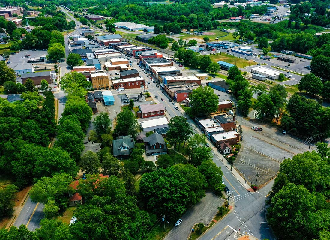 Insurance Solutions - Aerial View of a Main Street with Commercial Buildings in a Small Suburban Town in North Carolina Surrounded by Green Foliage